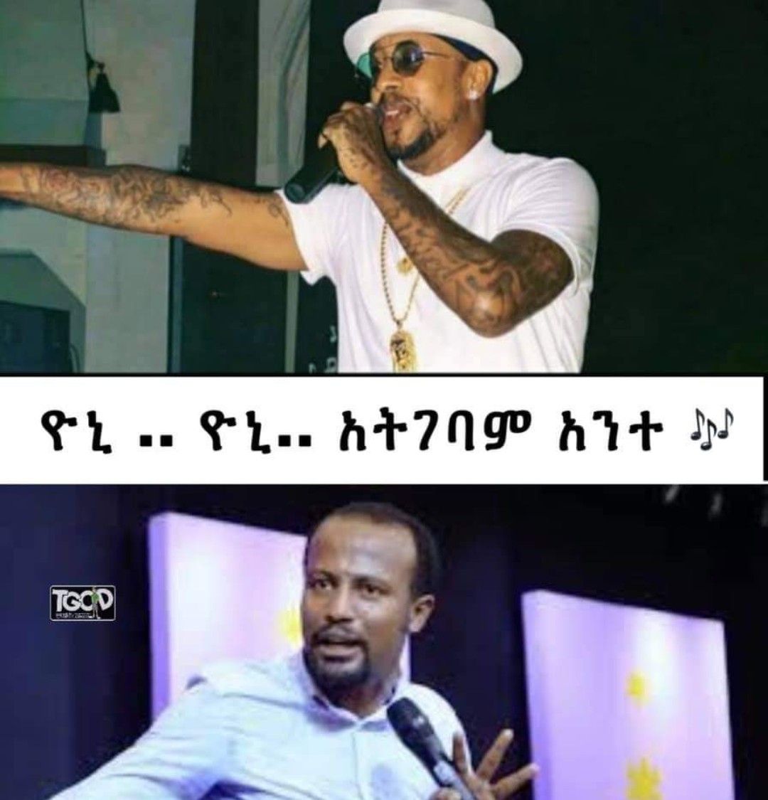 a man in a white shirt and a black hat is singing into a microphone